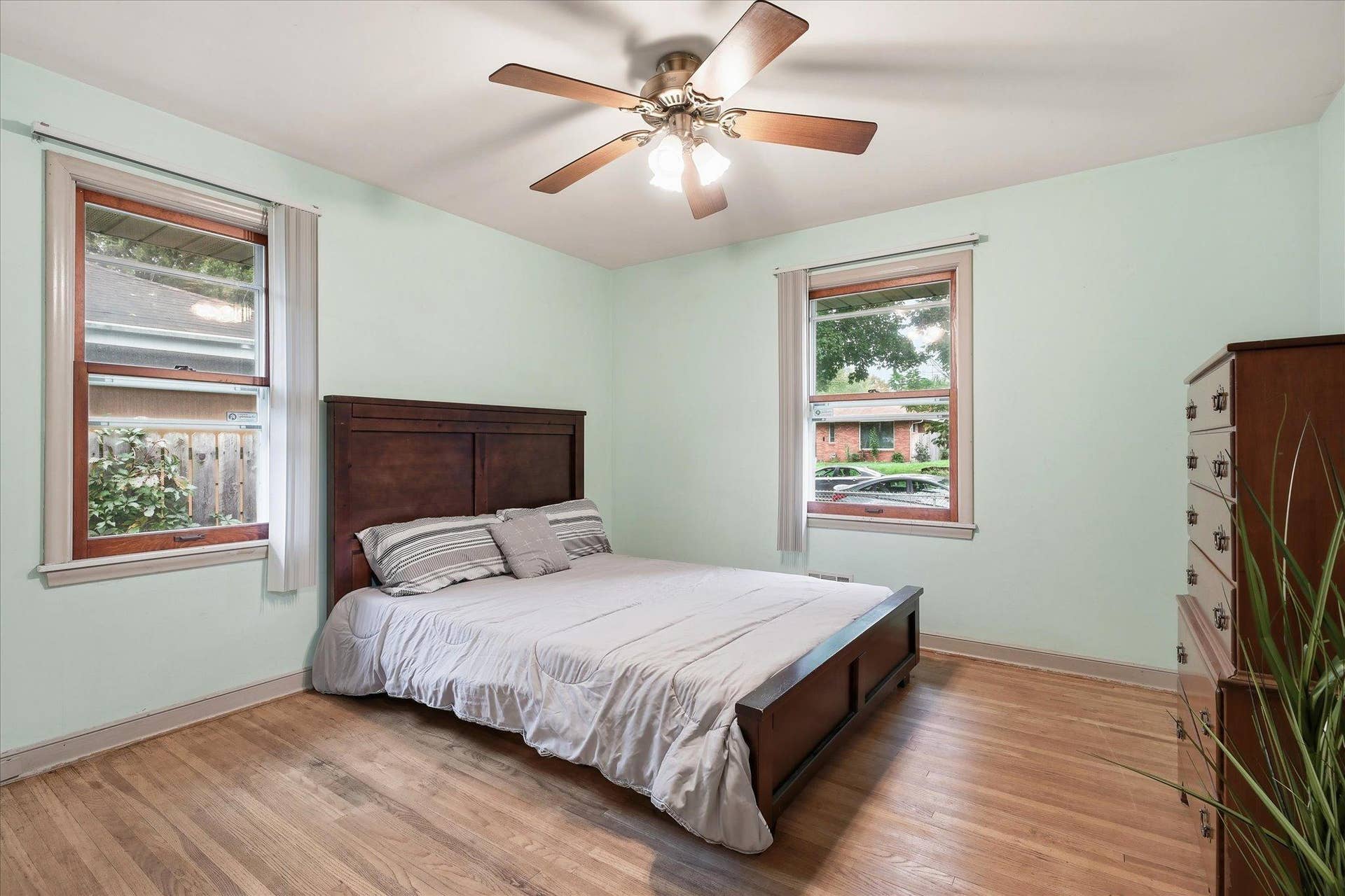 4840 N 6th Street, 41, Minneapolis, MN 55430 Main-level bedroom features hardwood floors, multiple windows for natural light, and a ceiling fan.