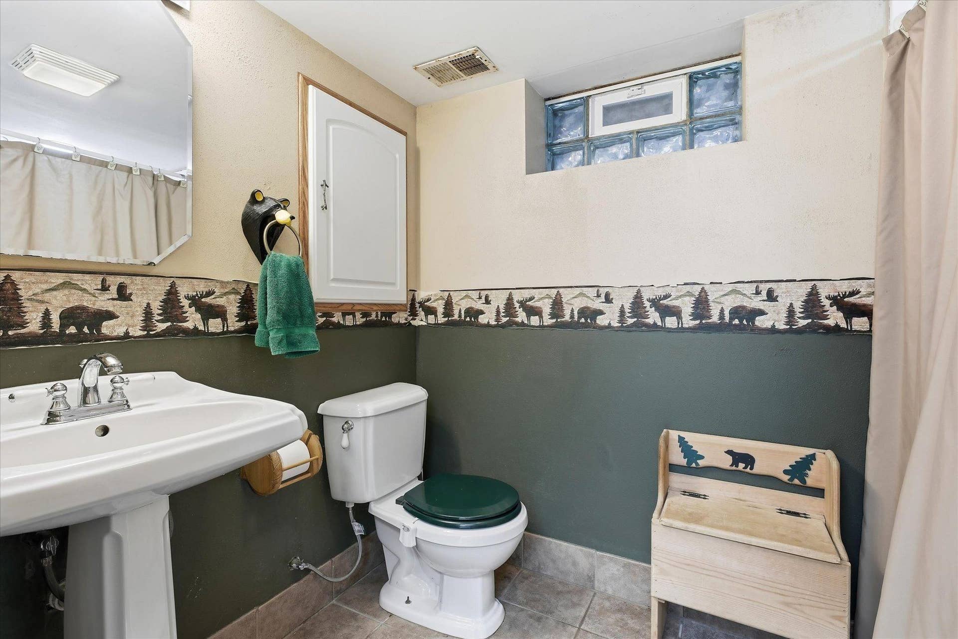 4840 N 6th Street, 41, Minneapolis, MN 55430 Convenient lower-level bathroom featuring a pedestal sink, tile flooring, and a glass block window.