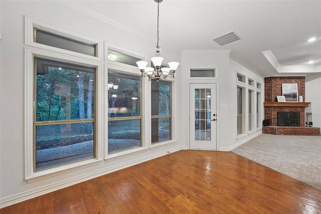 3421 Mindy Lane, Midlothian, TX 76065 Just off the kitchen, dining area featuring crown molding, a notable chandelier, wood finished floors, and visible vents