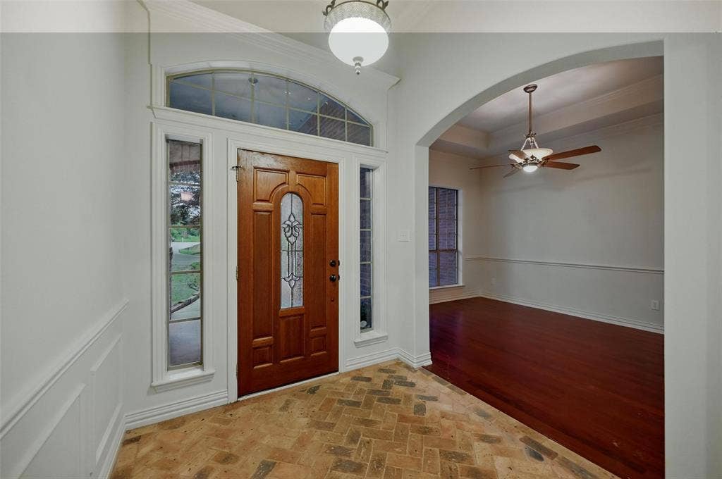 3421 Mindy Lane, Midlothian, TX 76065 Foyer entrance featuring ornamental molding, baseboards, ceiling fan, brick floor, and arched walkways