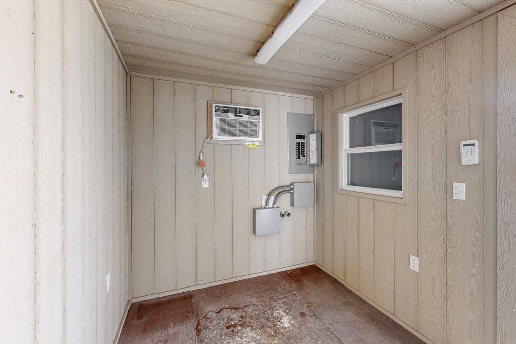 409 Copper Canyon Road, Argyle, TX 76226 Unfurnished room with electric panel, a wall unit AC, and wooden walls