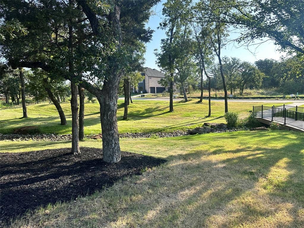 124 Park Avenue, Keller, TX 76262 Manicured green spaces featuring mature trees and a pedestrian bridge with black railings