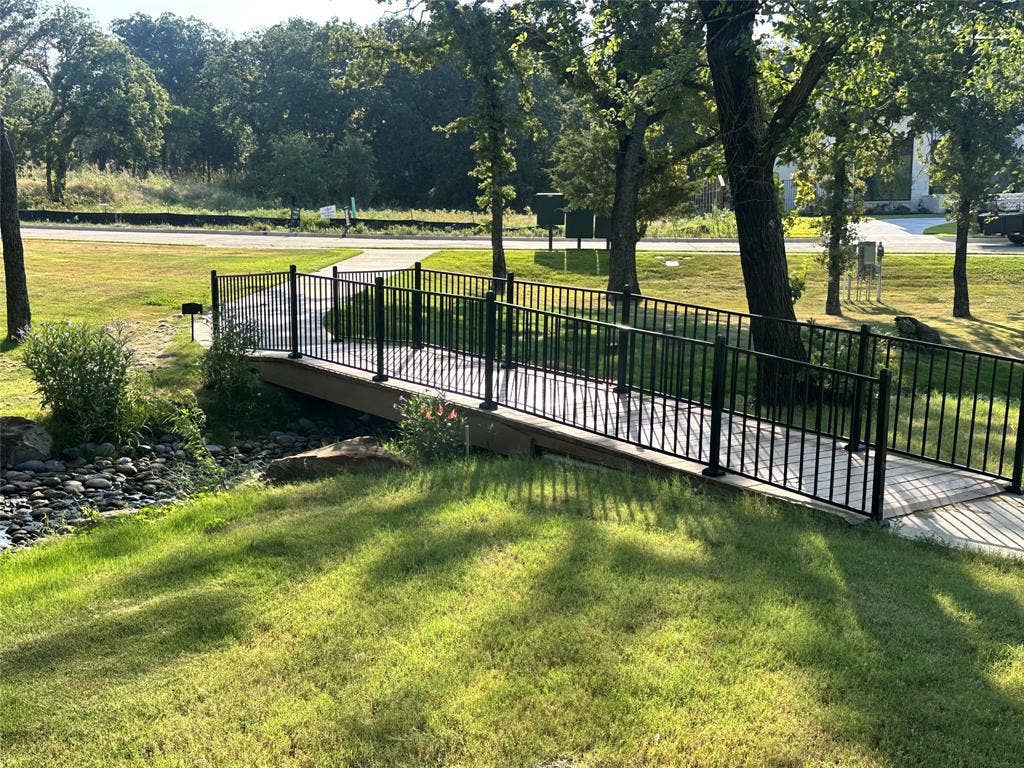 300 Park Avenue, Keller, TX 76262 Pedestrian bridge with black metal railings, crossing a rocky creek bed