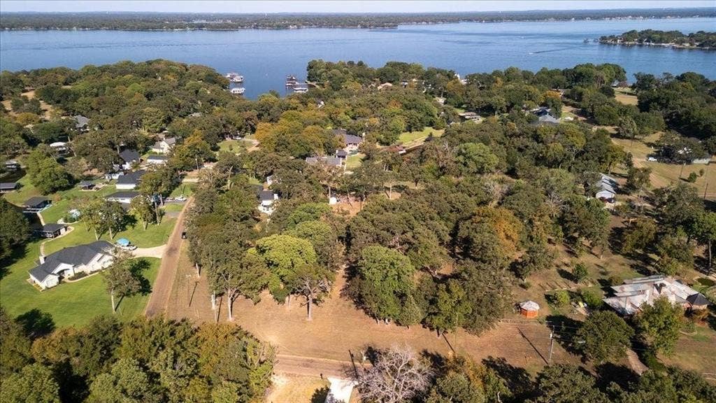 Birds eye view of property featuring a water view and a view of trees