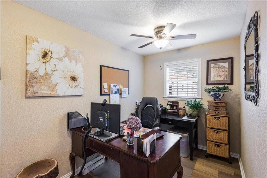 Home office with ceiling fan, a textured ceiling, baseboards, and wood finished floors