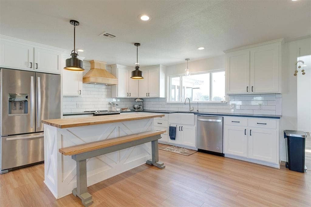 939 Twin Bends Road, Crawford, TX 76638 Kitchen with premium range hood, visible vents, white cabinetry, appliances with stainless steel finishes, and wooden counters