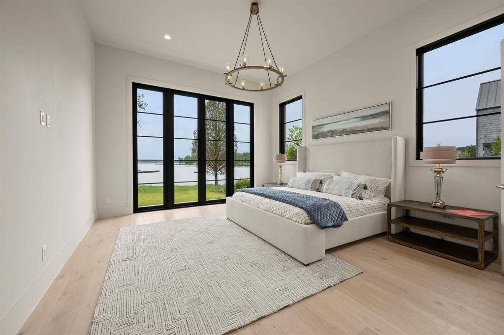 12121 Lighthouse Lane W, Malakoff, TX 75148 Bedroom with wood finished floors, a chandelier, a water view, recessed lighting, and baseboards