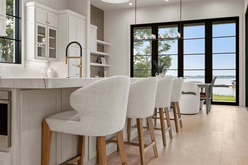12121 Lighthouse Lane W, Malakoff, TX 75148 Kitchen featuring a water view, white cabinets, light wood-type flooring, glass insert cabinets, and a kitchen breakfast bar