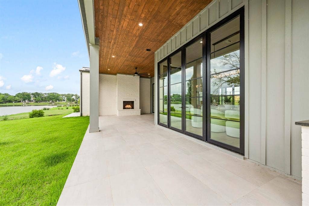 12121 Lighthouse Lane W, Malakoff, TX 75148 View of patio / terrace with a large fireplace, a water view, and a ceiling fan