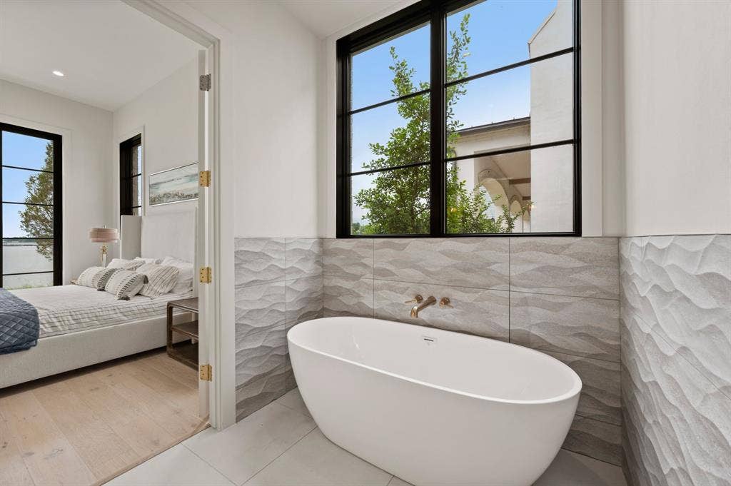 12121 Lighthouse Lane W, Malakoff, TX 75148 Ensuite bathroom featuring tile walls, a soaking tub, wainscoting, and tile patterned flooring