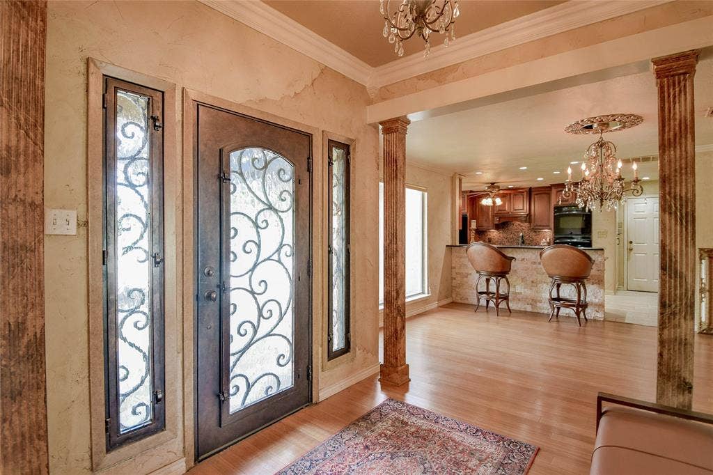 4009 Scenic Way, Granbury, TX 76049 Foyer entrance with decorative columns, a chandelier, ornamental molding, and light wood finished floors