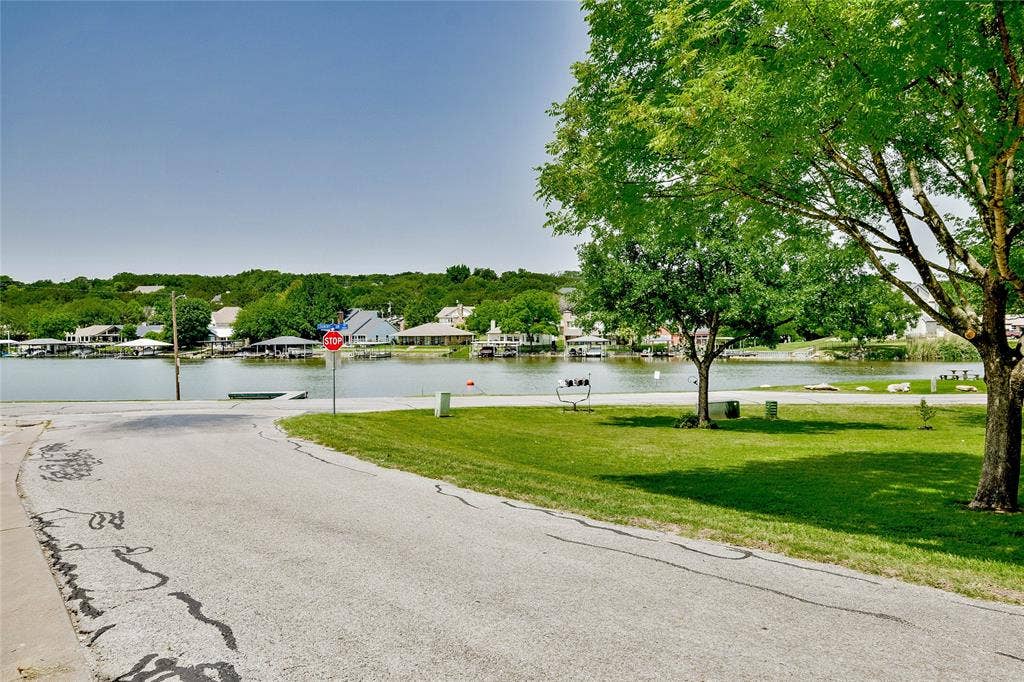 4009 Scenic Way, Granbury, TX 76049 View of asphalt street featuring traffic signs and a water view