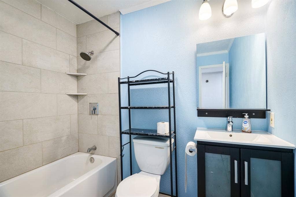 745 Oakland Street, Grand Prairie, TX 75052 Bathroom featuring vanity, shower / bathtub combination, toilet, and ornamental molding