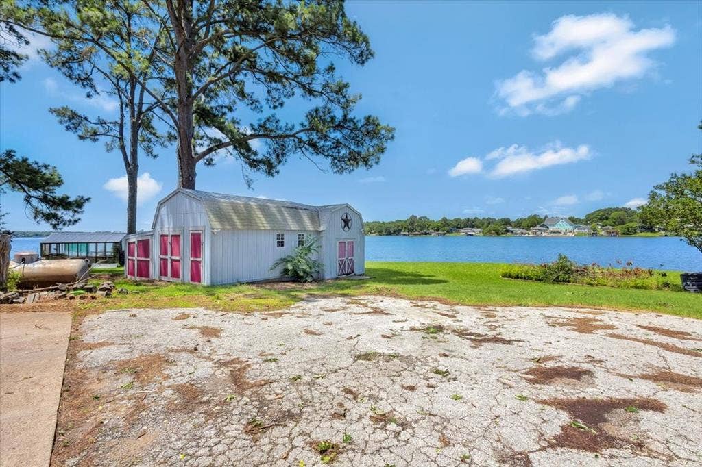 6903 Scott Street, Eustace, TX 75124 View of green lawn with a water view and a storage unit