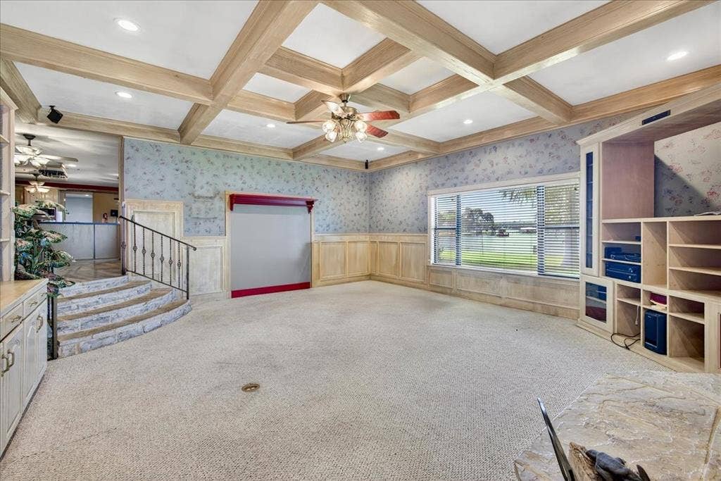 6903 Scott Street, Eustace, TX 75124 Unfurnished living room featuring ceiling fan, carpet, beam ceiling, coffered ceiling, and wallpapered walls