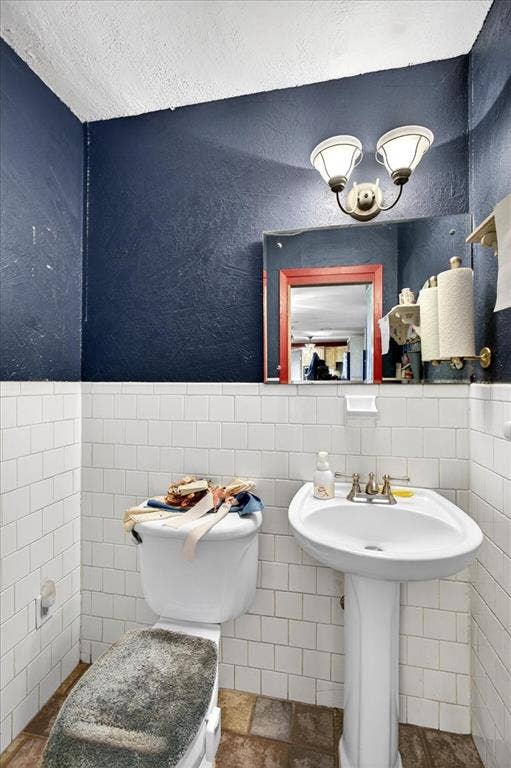 6903 Scott Street, Eustace, TX 75124 Bathroom with tile walls and wainscoting