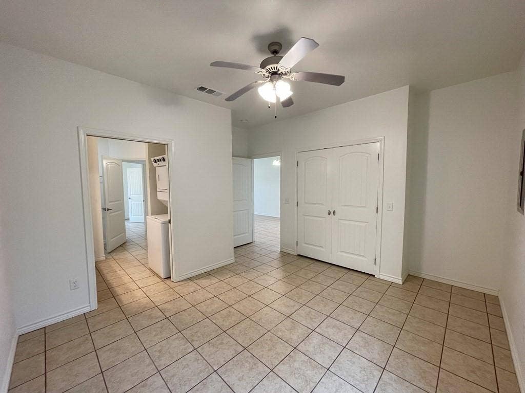 507 E Bryson Street, #A, Athens, TX 75751 Unfurnished bedroom featuring light tile patterned floors, baseboards, a closet, and ceiling fan