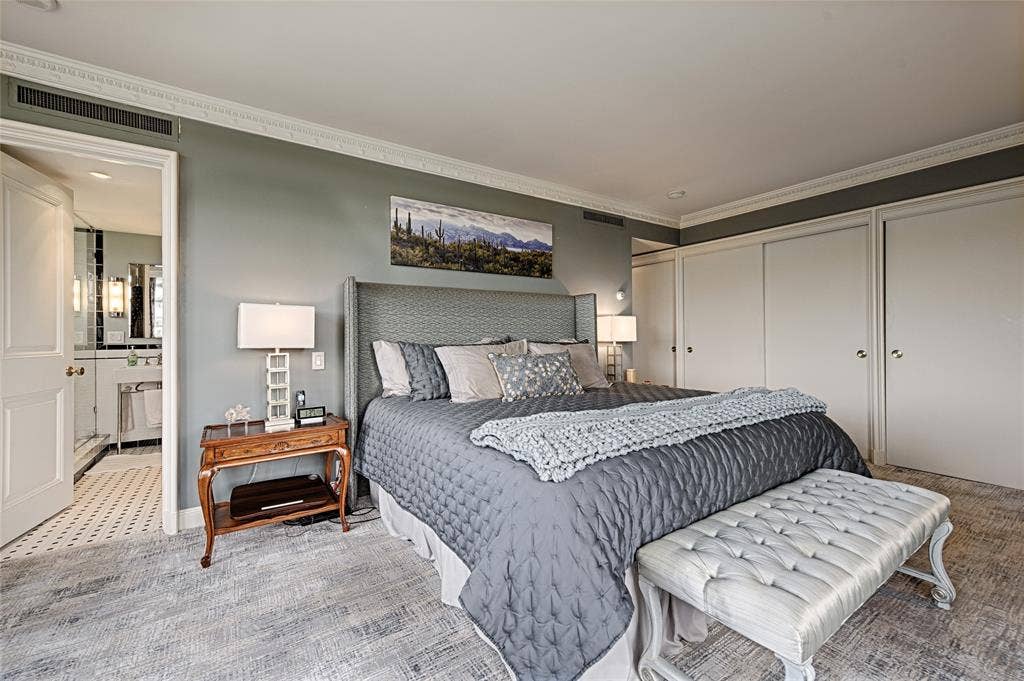 3525 Turtle Creek Boulevard, #4E, Dallas, TX 75219 Owners suite with crown molding, ensuite bathroom, closets, and light colored carpet