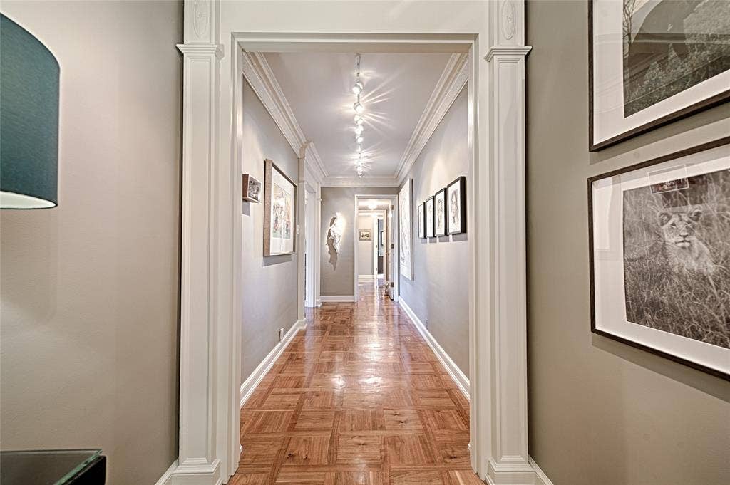 3525 Turtle Creek Boulevard, #4E, Dallas, TX 75219 Corridor gallery with ornamental molding and baseboards looking towards the second bedroom