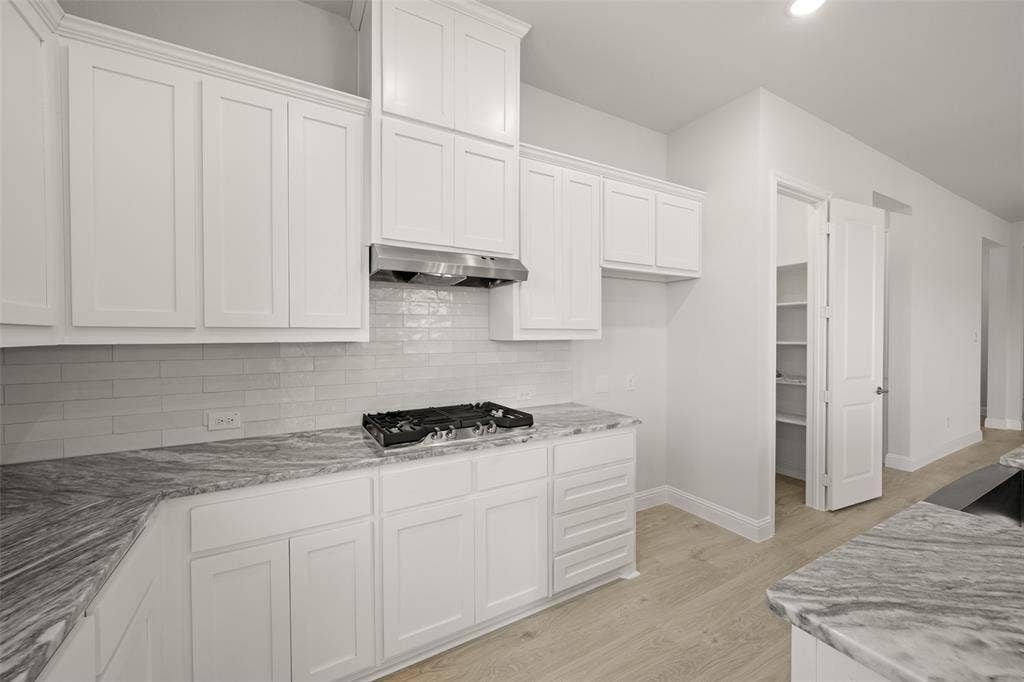 413 Wabash Drive, Waxahachie, TX 75167 Kitchen with exhaust hood, stainless steel gas cooktop, white cabinets, and light wood-type flooring