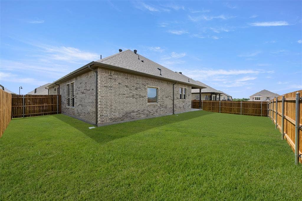 413 Wabash Drive, Waxahachie, TX 75167 Back of house featuring brick siding, a fenced backyard, and roof with shingles