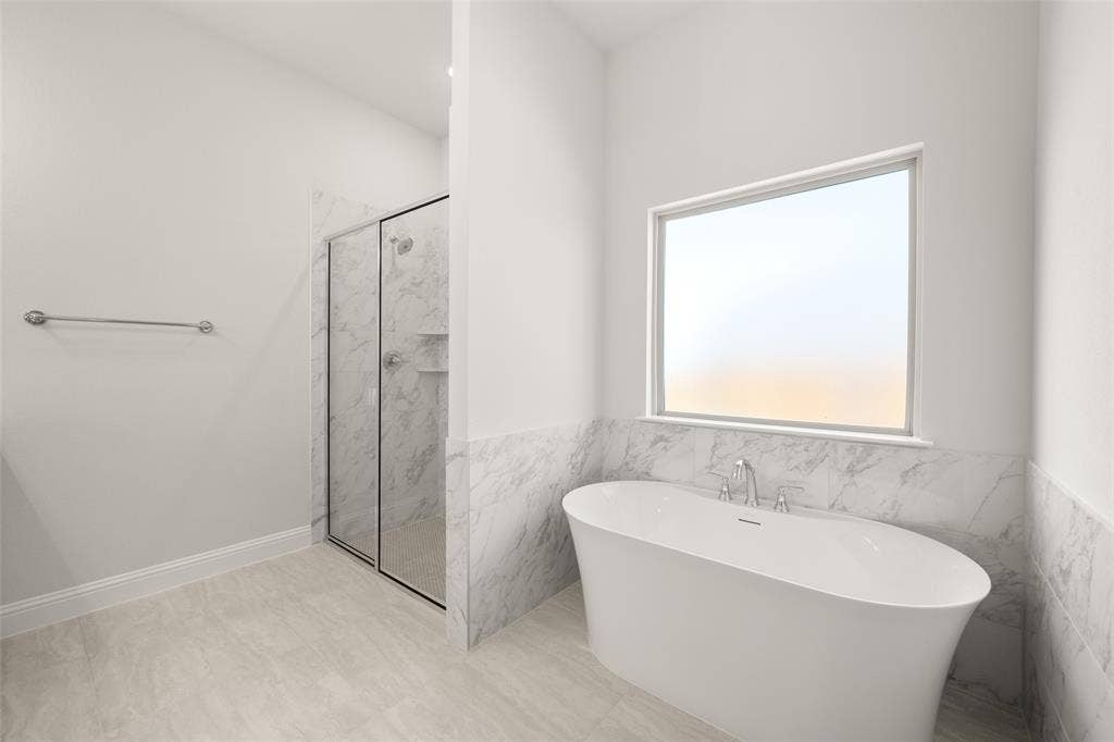 413 Wabash Drive, Waxahachie, TX 75167 Full bathroom with a freestanding tub, a marble finish shower, tile walls, and wainscoting