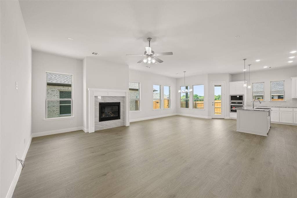 413 Wabash Drive, Waxahachie, TX 75167 Unfurnished living room featuring recessed lighting, ceiling fan, a high end fireplace, and light wood-style floors