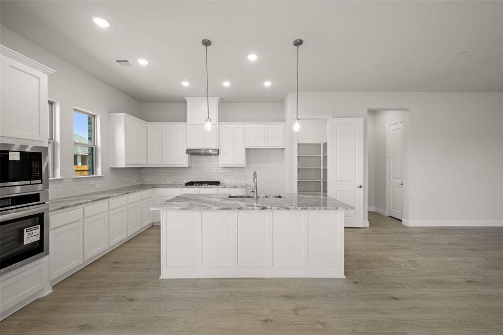 413 Wabash Drive, Waxahachie, TX 75167 Kitchen with stainless steel appliances, white cabinets, backsplash, a center island with sink, and recessed lighting