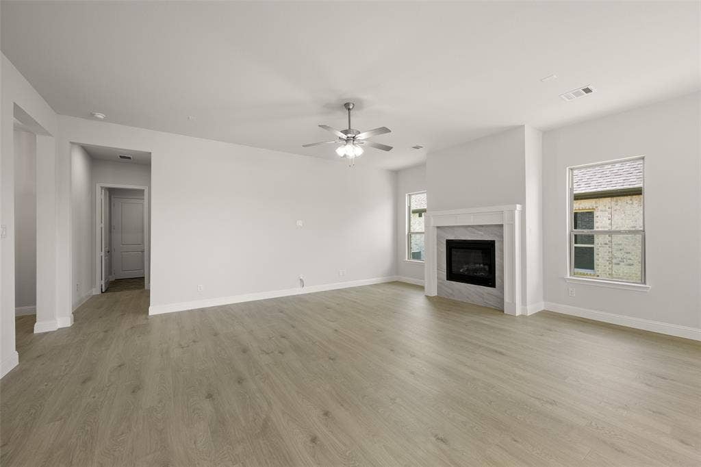 413 Wabash Drive, Waxahachie, TX 75167 Unfurnished living room featuring ceiling fan, light wood-type flooring, and a premium fireplace