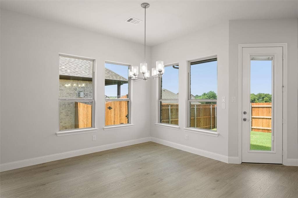 413 Wabash Drive, Waxahachie, TX 75167 Unfurnished dining area featuring a chandelier and wood finished floors