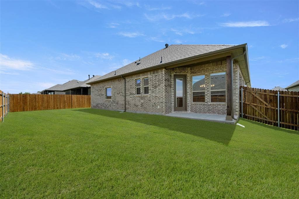 413 Wabash Drive, Waxahachie, TX 75167 Back of house featuring brick siding, a fenced backyard, a patio, and a shingled roof