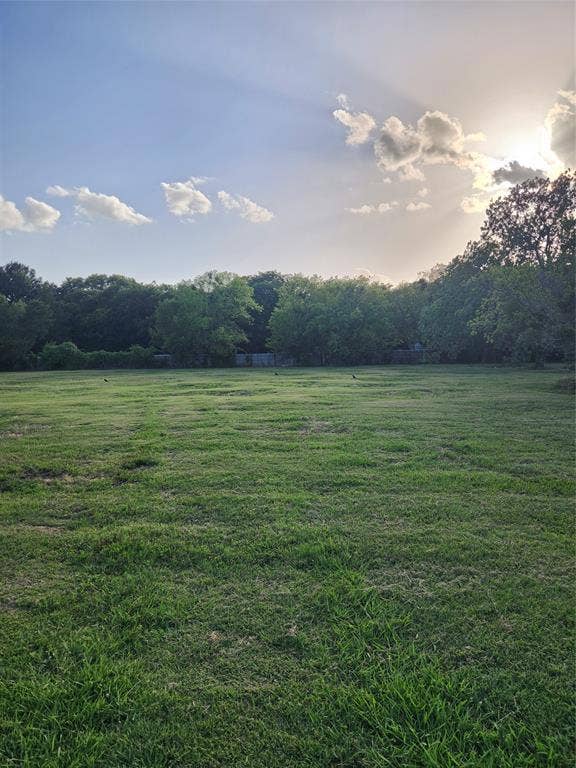 View of grassy yard with a wooded view and a view of countryside
