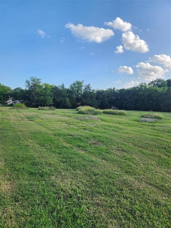 View of grassy yard featuring a view of countryside and a wooded view