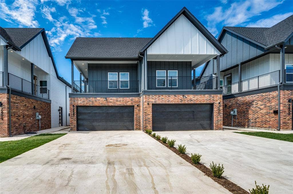 2405 Jeffries Street, Dallas, TX 75215 Example of similar build - View of front of property with driveway, a balcony, board and batten siding, and an attached garage