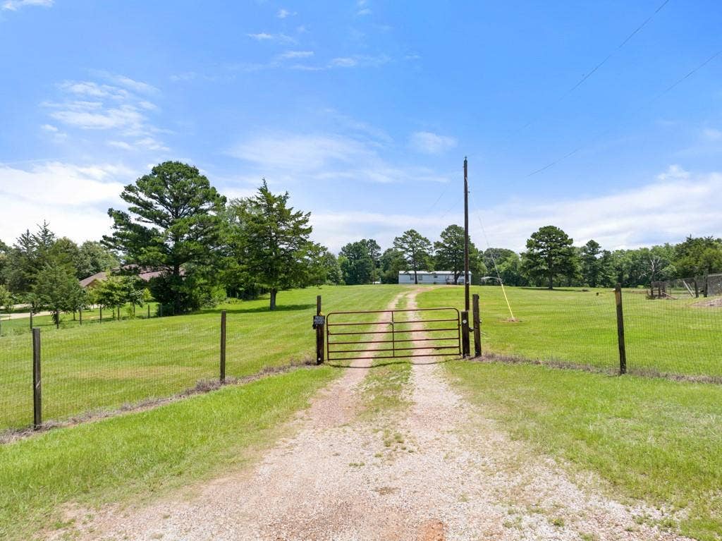 5353 CR 385, Tyler, TX 75708 View of dirt / gravel road with a rural view, a gate, and a gated entry