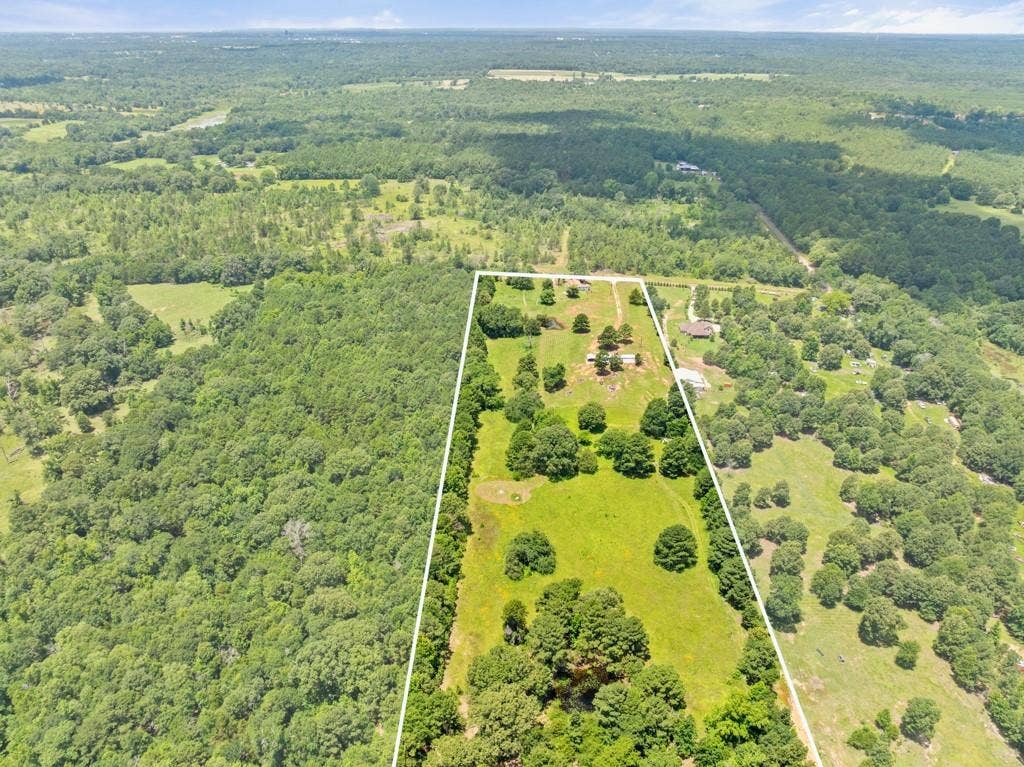 5353 CR 385, Tyler, TX 75708 Aerial view of property and surrounding area featuring a heavily wooded area and property parcel outlined
