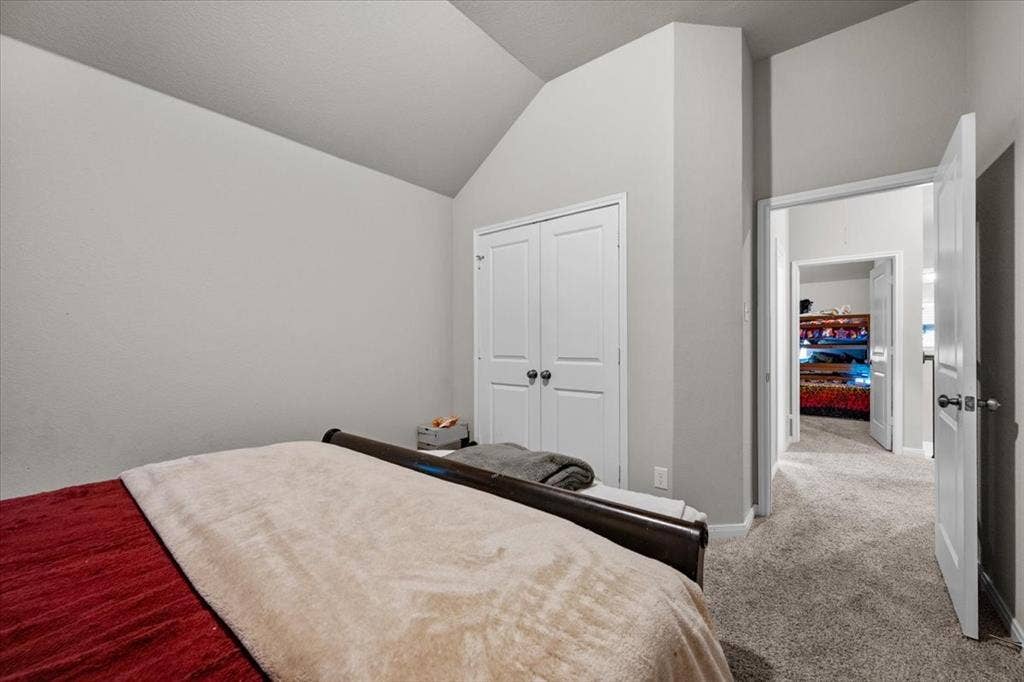 3501 Beutel Road, Waco, TX 76655 Bedroom featuring vaulted ceiling, light carpet, and a closet