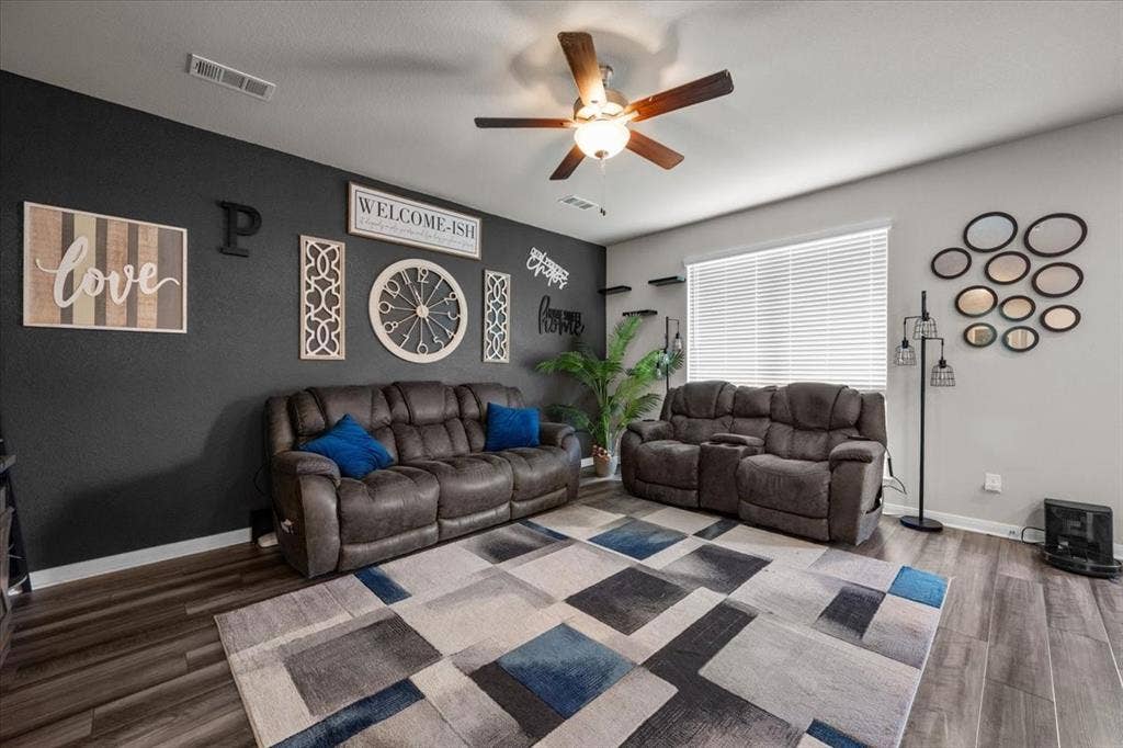 3501 Beutel Road, Waco, TX 76655 Living area with wood finished floors, a ceiling fan, and a wood stove