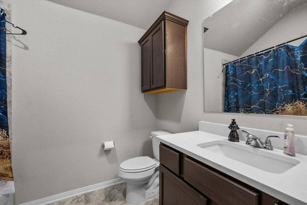 3501 Beutel Road, Waco, TX 76655 Bathroom with vanity, a textured wall, and lofted ceiling