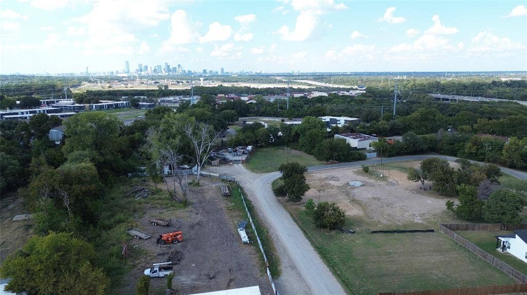 3733 Kolloch Drive, Dallas, TX 75216 Aerial view of property's location with city skyline and a tree filled landscape