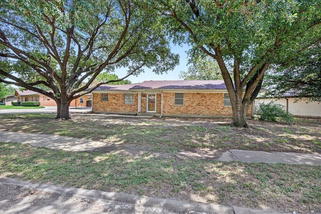 Ranch-style house featuring brick siding