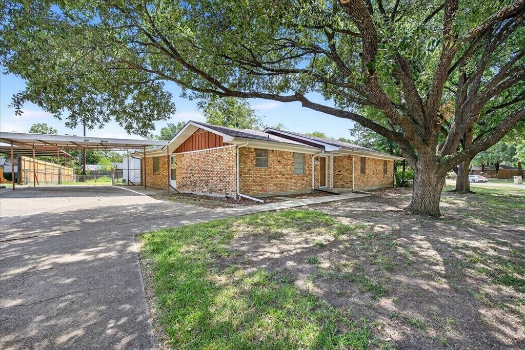 View of side of property with concrete driveway and brick siding