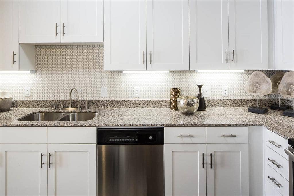 908 N Bishop Avenue, #2-103, Dallas, TX 75208 Kitchen featuring backsplash and white cabinetry