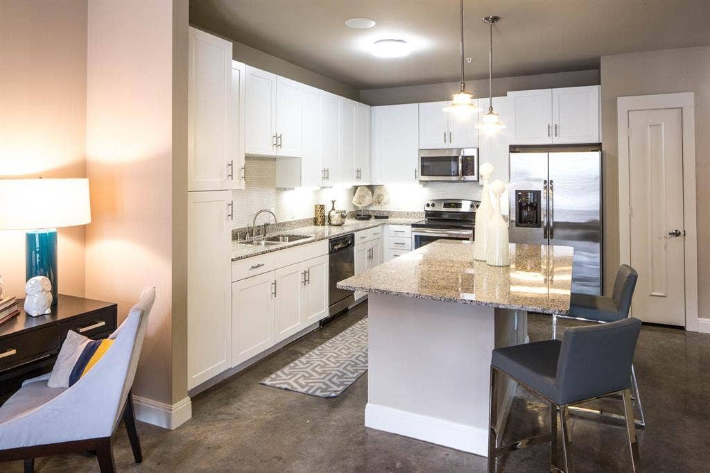 908 N Bishop Avenue, #2-103, Dallas, TX 75208 Kitchen with light stone counters, decorative light fixtures, stainless steel appliances, and white cabinets