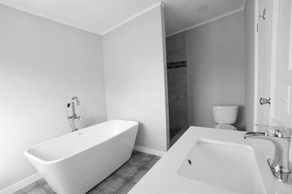 245 Oak Hill Court, Waxahachie, TX 75167 Bathroom featuring a freestanding bath, tiled shower, and a textured ceiling