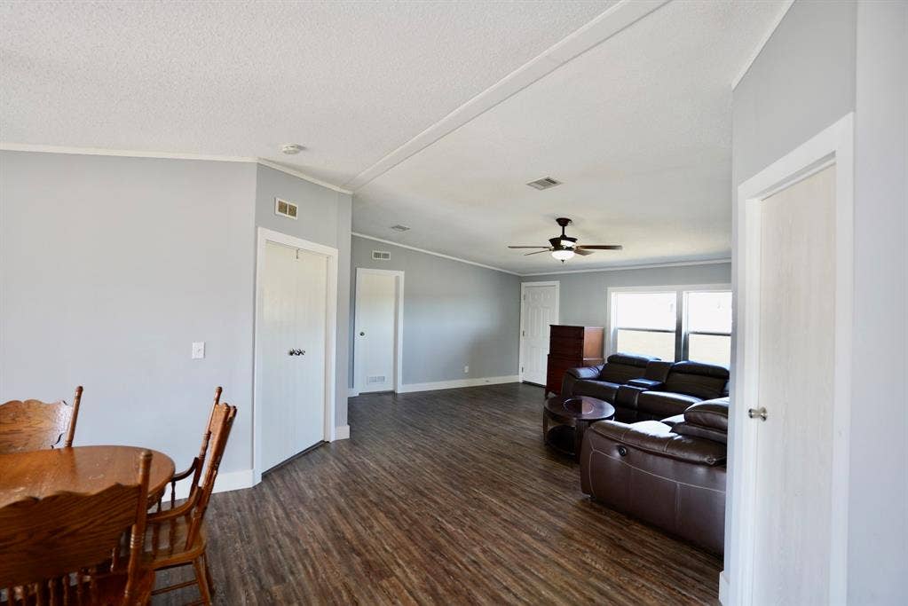 245 Oak Hill Court, Waxahachie, TX 75167 Living area featuring ornamental molding, dark wood-type flooring, vaulted ceiling, and ceiling fan
