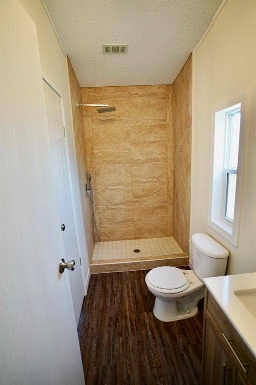 245 Oak Hill Court, Waxahachie, TX 75167 Bathroom with dark wood-style floors, vanity, a stall shower, and a textured ceiling