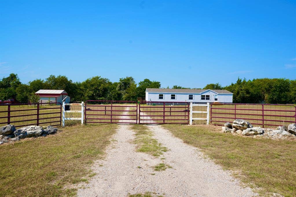 245 Oak Hill Court, Waxahachie, TX 75167 View of dirt / gravel driveway featuring a gate and a gated entry
