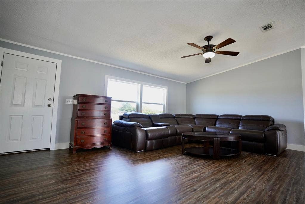 245 Oak Hill Court, Waxahachie, TX 75167 Living area with dark wood-type flooring, crown molding, vaulted ceiling, and a ceiling fan
