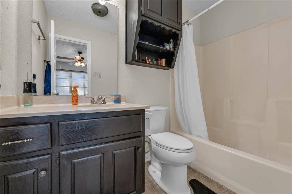 1349 S 11th Street, Waco, TX 76706 Full bath featuring shower / bath combo, vanity, light tile patterned floors, a textured ceiling, and ceiling fan